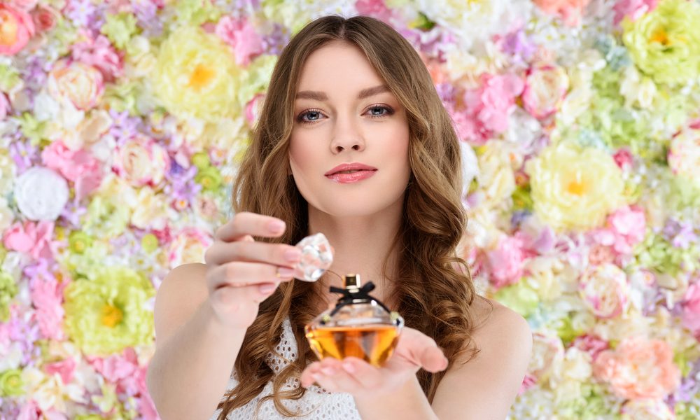 vrouw die parfum op spuit