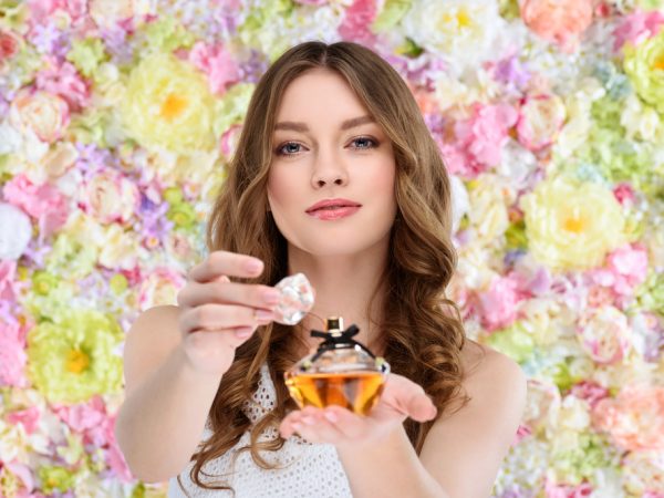 vrouw die parfum op spuit